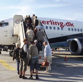 De sidste kufferter lastes p� flyet - og s� er der afgang fra Aalborg Lufthavn i str�lende sol.
